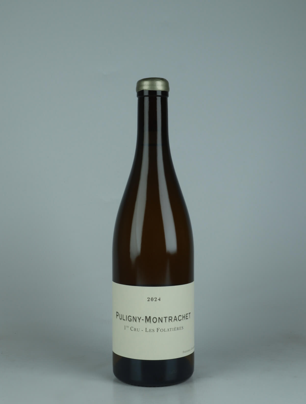 A bottle 2024 Puligny Montrachet 1. Cru - Folatières Hvidvin from Frédéric Cossard, Bourgogne in Frankrig